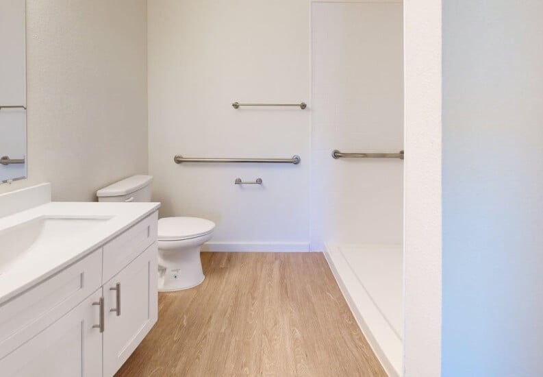 Clean and Spacious Bathroom with Grab Bar at Independent Living Facility Clean and Spacious Bathroom with Grab Bar at Independent Living Facility
