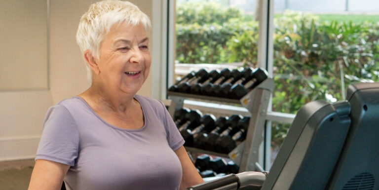 Senior Woman Using a Treadmill in a Fitness Center at an Independent Living Facility